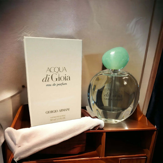 Acqua di Gioia perfume bottle and packaging on a wooden surface