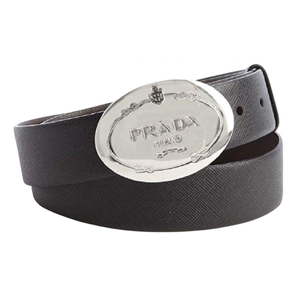 Prada Black Saffiano Leather Belt with Engraved Oval Buckle -  This Belt features black saffiano leather paired with a distinctive oval silver buckle engraved with the Prada logo. Its timeless design makes it a versatile accessory that complements any outfit with sophistication.Model: 2CM046Size: 110/44Black Saffiano LeatherSilver-toned hardwarePalladium plaque buckleIncludes Prada authenticity card and dust bagMade in Italy Shop Bags 