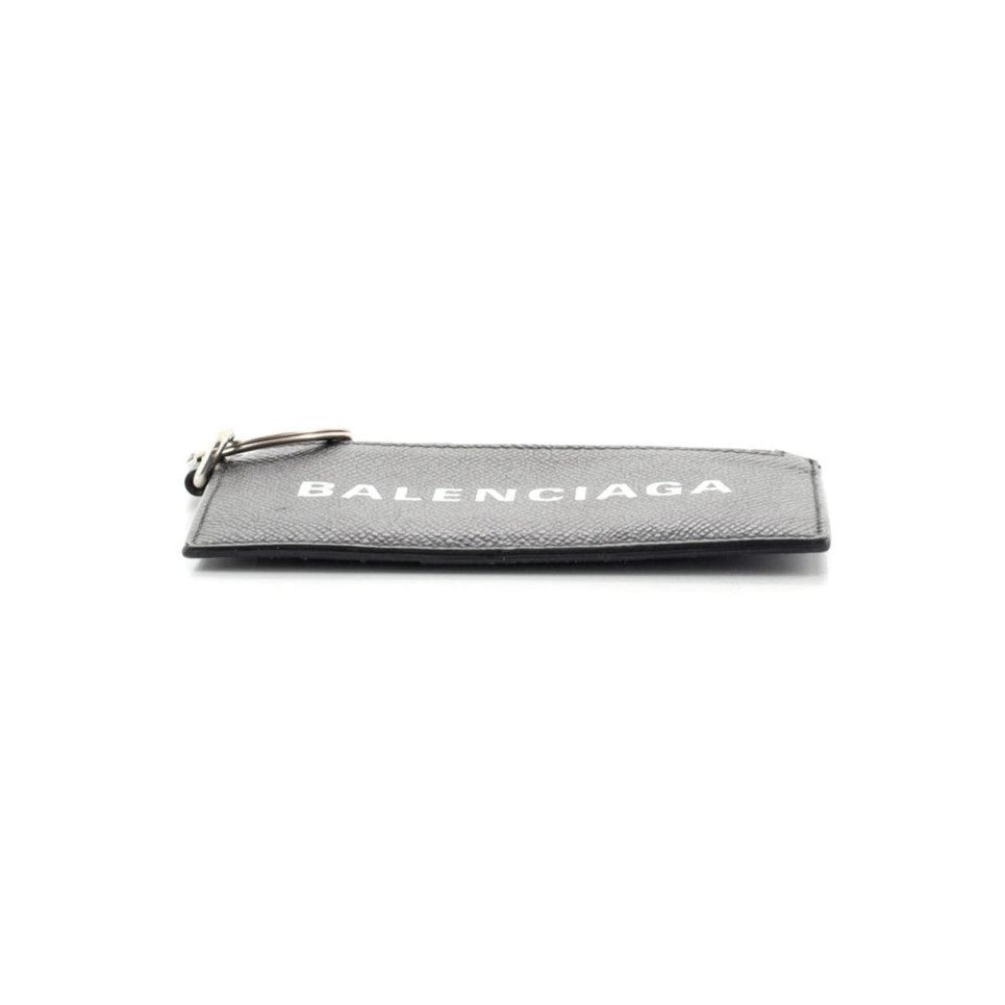 Balenciaga Wallet: Unisex Black Wallet & Card Holder with Lanyard -  Made from black textured leather, this Balenciaga Wallet and card case has a zipped pouch and four card slots, complete with a detachable lanyard for easy portability.Model: 594548Black Calfskin leatherWhite Balenciaga logoBlack leather interior liningFour card slotsTop zipper pocket Detachable leather lanyardStrap drop: 23" Measurements: 5.1 x 0.5 x 3" (LWH)Includes authenticity cardsMade in Italy Shop Bags 