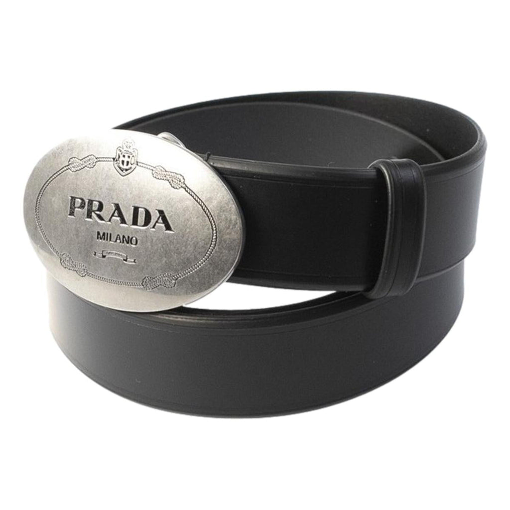Prada Men's Navy Blue Saffiano Leather Belt with Silver Buckle -  This timeless Prada Belt showcases a matte silver oval buckle engraved with the Prada Milano logo. Crafted from saffiano cross-grain leather, it offers durability and style suitable for daily use.Model: 2CM046Size: 105/42Blue Saffiano leatherBrushed matte silver oval buckleIncludes Prada dust bag and authenticity cardsMade in Italy Shop Bags 