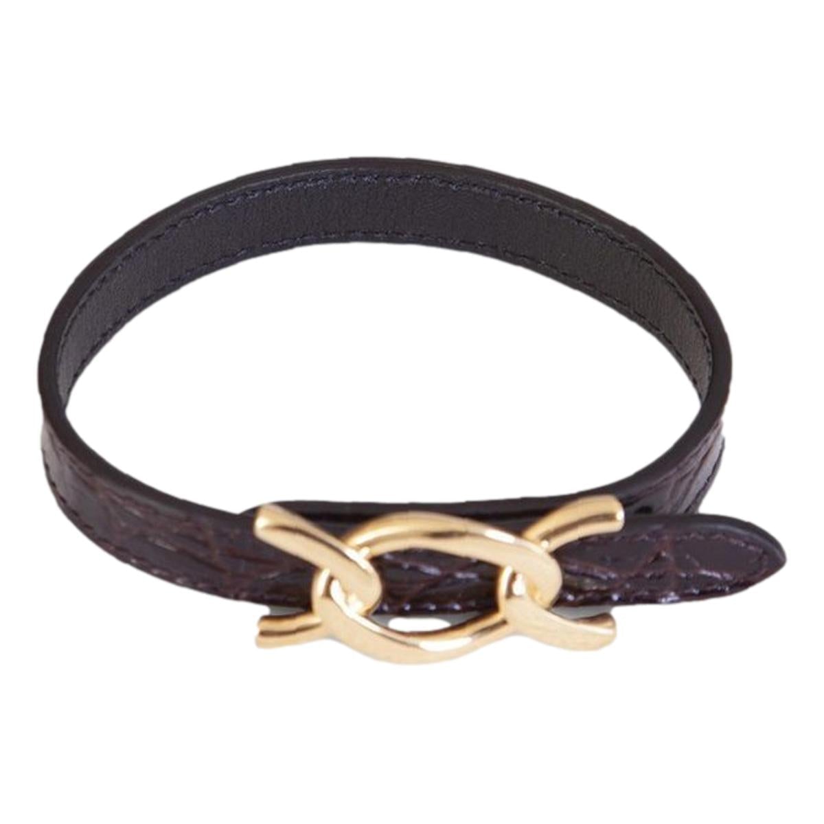 Saint Laurent Croc Embossed Leather Chain Bracelet - Elegance -  This Saint Laurent Bracelet features black leather embossed with a crocodile pattern, paired with a bold gold cub chain. The interior bears a subtle debossed "Saint Laurent" logo. Perfect for elevating daily wear or adding a refined touch to formal ensembles.Model: 640736Calfskin leather with crocodile texture embossedGold curb chain metalAdjustable hook closureSaint Laurent logo embossed on interiorIncludes authenticity cardsMade in Italy