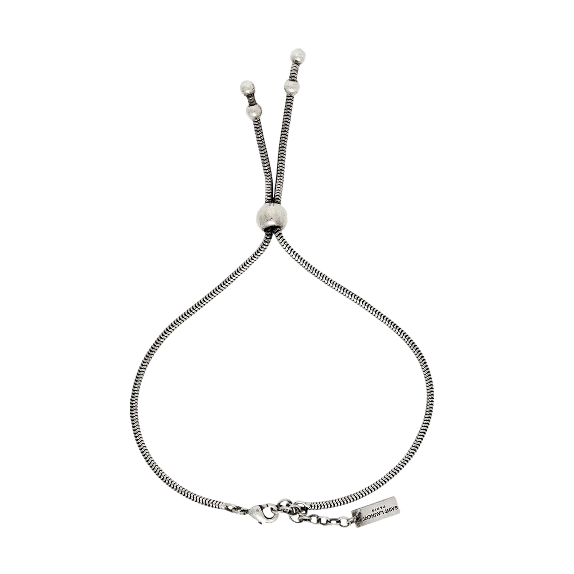 Elegant Tie Bracelet, Shop Bags - Saint Laurent Silver Bolo Style -  The Saint Laurent Silver bolo Tie Bracelet offers a sophisticated twist to elevate your look. Featuring a sleek silver-tone design combined with the iconic bolo tie style, it strikes a refined balance between casual wear and elegant appeal.Model Number: 667365Silver-tone chainLobster claw closureMetal tag with logo embossedAuthenticity cards and box includedMade in Italy Shop Bags 