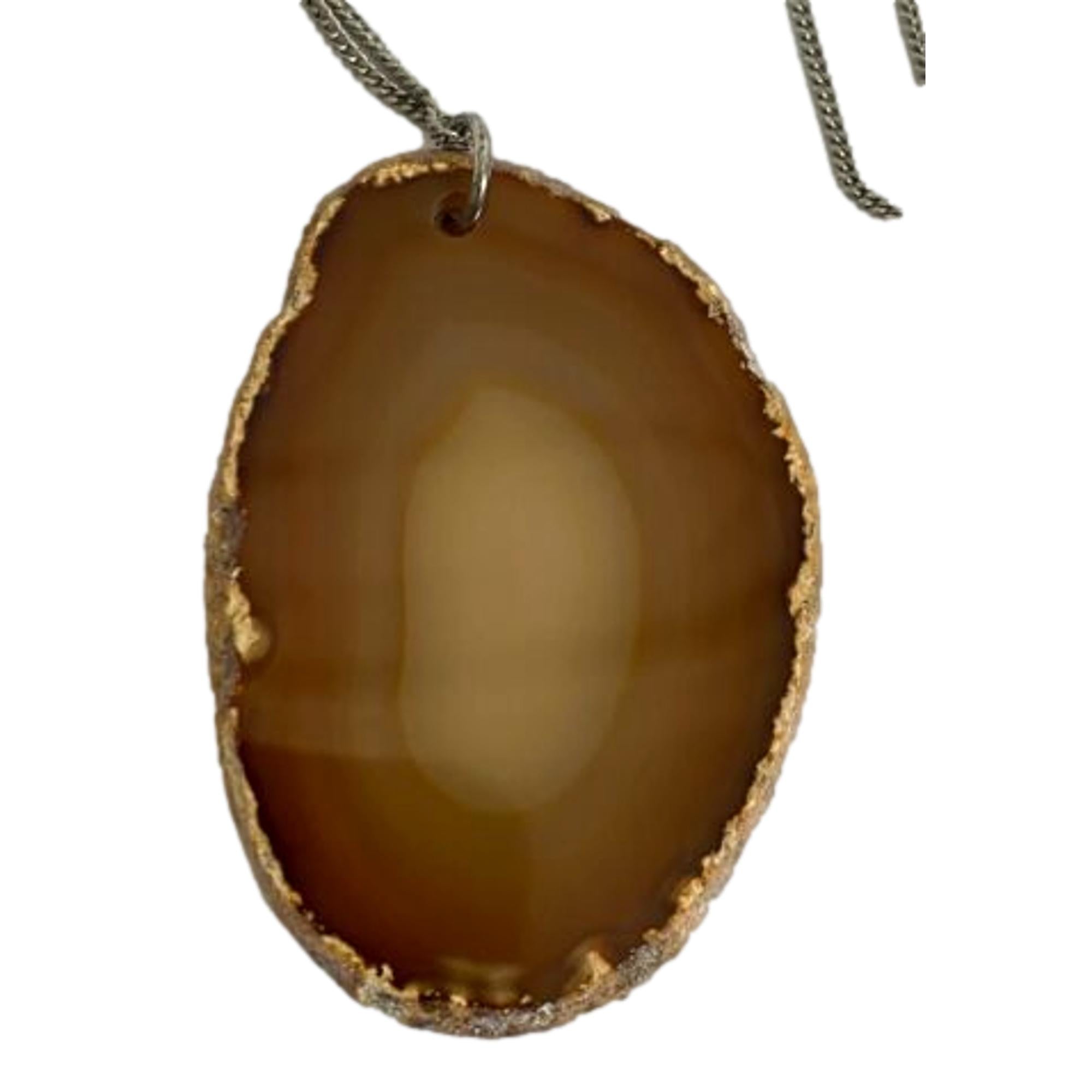 Saint Laurent Agate Necklace, Brass Chain - Elegant Orange-Brown Stone -  The Saint Laurent Agate Necklace combines a lengthy silver brass chain with a lobster claw clasp for adjustable wear. Its semi-precious agate stone showcases warm orange and brown hues, framed in silver. The stone’s color shifts subtly with light and outfit, offering a dynamic and refined accessory. Model: 602594Agate stoneAdjustable chainLobster claw closureIncludes authenticity card and boxMade in Italy Shop Bags 
