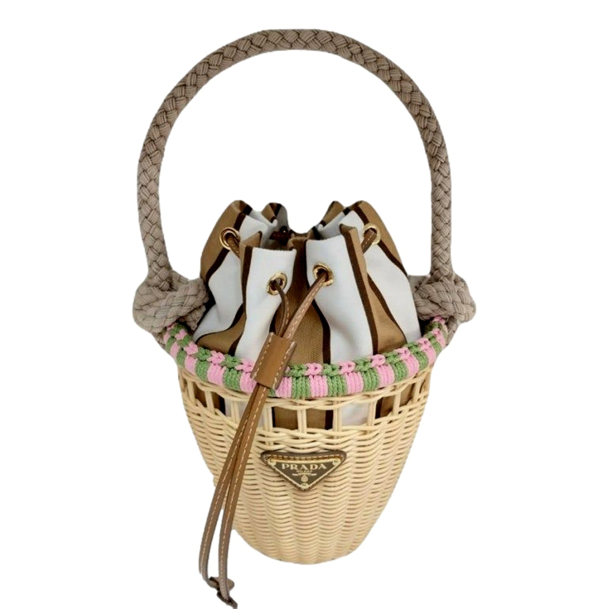 A Prada wicker bucket bag with a braided rope handle, featuring a white and brown leather bucket insert, a pink and green woven trim, and a gold-tone metal logo plaque on the front.